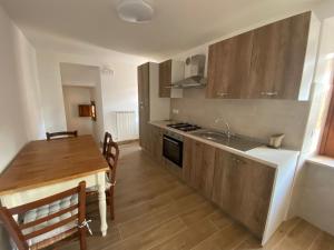 a kitchen with a wooden table and a kitchen with a dining room at Casa Saotta in Collimento