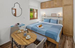 a bedroom with a bed and a wooden table with a table at Beautiful Home In Rovinj With Wifi in Rovinj