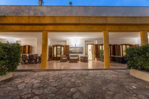 a lobby with yellow columns and tables and chairs at Villa il panorama sullo Ionio in Tuglie