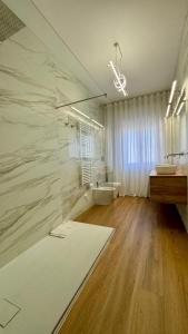 baño con 2 lavabos y una gran pared de mármol en Apartment Suite, en Montesilvano