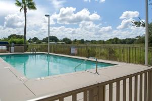 a swimming pool with a fence around it at Serena Inn in Kissimmee