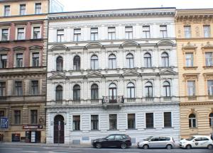 a large white building with cars parked in front of it at Prague-1 Hostel in Prague
