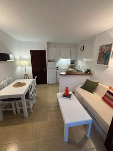 a living room with a couch and tables and a kitchen at Apartamento costa Menorca in Cala'n Bosch