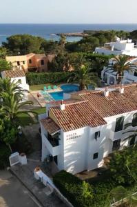 an aerial view of a house with the ocean in the background at Apartamento costa Menorca in Cala'n Bosch