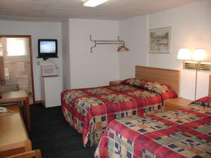 a hotel room with two beds and a television at Valley Inn - Lebanon Oregon in Lebanon +11 photos
