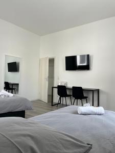 a bedroom with two beds and a table and chairs at Homburg-Residenz in Bad Homburg vor der Höhe