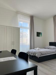 a bedroom with a bed and a table and a window at Homburg-Residenz in Bad Homburg vor der Höhe +12 photos