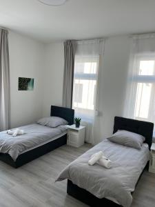 a bedroom with two beds and two windows at Homburg-Residenz in Bad Homburg vor der Höhe
