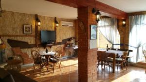 a dining room with tables and chairs and a tv at B&B Pansion Zlatko in Metajna