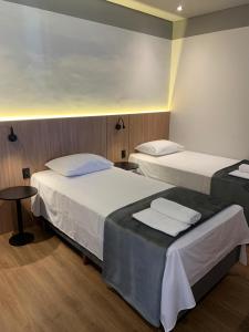 a room with two beds and a table at Grand Hill Hotel in Piraí do Sul +25 photos