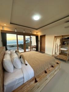 a bedroom with a large bed with a balcony at D Alam Batur in Kubupenlokan