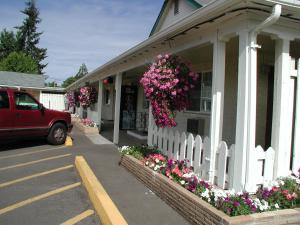 a house with a white fence and flowers on it at Valley Inn - Lebanon Oregon in Lebanon