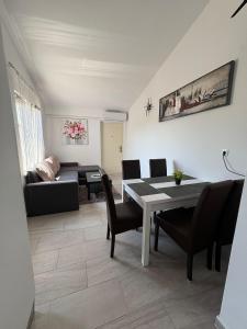 a living room with a table and chairs and a couch at Apartmani Versizo Rogoznica in Sevid