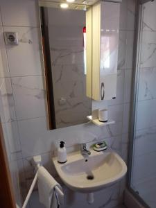 a white bathroom with a sink and a mirror at Apartmani Versizo Rogoznica in Sevid +16 photos