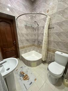 a bathroom with a toilet and a sink and a shower at Firdavsiy Guesthouse - Уютный Апарт-отель у озера in Bukhara +31 photos