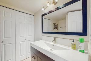 a bathroom with a white sink and a mirror at Palm Springs Sunrise Condo in Palm Springs +10 photos