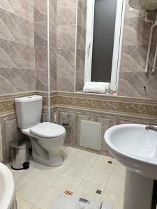 a bathroom with a toilet and a sink at Firdavsiy Guesthouse - Уютный Апарт-отель у озера in Bukhara