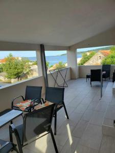 a room with chairs and tables and a view of the ocean at Apartmani Versizo Rogoznica in Sevid