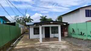 a small white house with a green fence at Apartamentos GoZu # 1 in Puerto Viejo