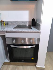 una cocina con estufa y encimera en Departamento nuevo en Rondizzoni, en Santiago 3 fotos más