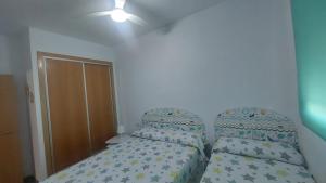 a bedroom with two beds and a ceiling at Este in La Playa de la Torre de Piles