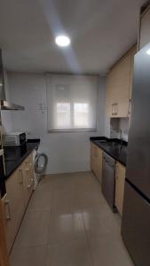 a small kitchen with a sink and a refrigerator at Este in La Playa de la Torre de Piles +3 photos