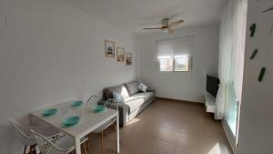 a living room with a couch and a table at Este in La Playa de la Torre de Piles