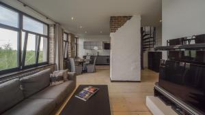 Una sala de estar con un sofá y un televisor. en Riga Luxury Loft with Terrace, en Riga