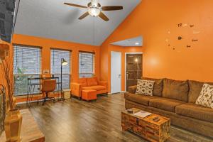 sala de estar con paredes de color naranja y sofá en SW Houston Eclectic Living, en Houston