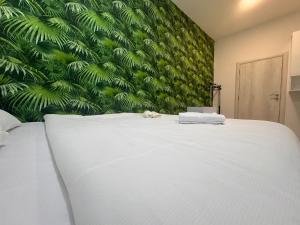 - un lit blanc dans une chambre dotée d'un mur vert dans l'établissement Central Point Sarajevo Apartments, à Sarajevo