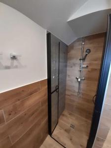 a bathroom with a shower with a wooden floor at DOMEK Łapalice Kaszuby in Łapalice