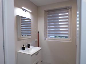 a bathroom with a white sink and two windows at Apartamenty u Załogi in Zakopane +25 photos