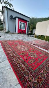 a red rug on the ground in front of a house at Sweet house Qalaciq in İsmayıllı