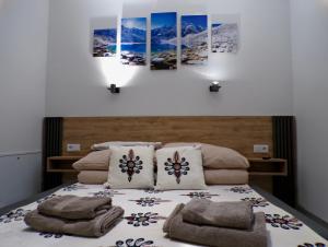 a bedroom with a bed with four paintings on the wall at Apartamenty u Załogi in Zakopane