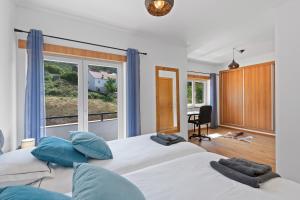 una camera da letto con un grande letto con cuscini blu e una finestra di Estrela da Serra a Unhais da Serra