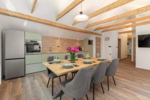 eine Küche und ein Esszimmer mit einem Holztisch und Stühlen in der Unterkunft Brlog 2 in Zgornje Gorje