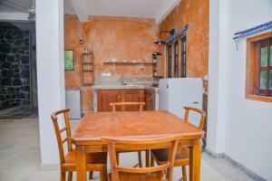a kitchen with a wooden table and chairs at Unawatuna Nature Villa in Unawatuna