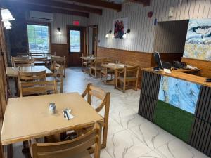 a dining room with tables and chairs and a tv at au pied du nord in Saint-Jérôme