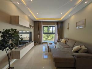a living room with a couch and a tv at Salus Holiday Apartment in Victoria