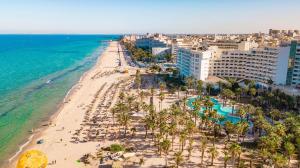 een luchtzicht op een strand met palmbomen en de oceaan bij Riadh Palms- Resort & Spa in Sousse
