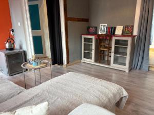 a living room with a bed and a table at Au Richebourg Nogent in Nogent-sur-Seine