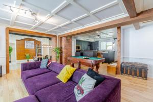 a living room with a purple couch and a pool table at Old-Time Charm - 12 Guests - Billiards & Hot Tub in Sainte-Anne-de-Beaupré