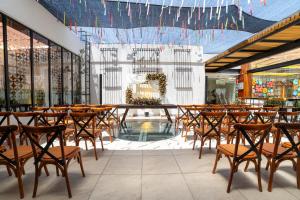 a restaurant with a bunch of chairs and a pool at Casa de la Luz Hotel Boutique in Mexico City