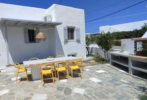 eine Terrasse mit einem Tisch und gelben Stühlen in der Unterkunft Fos residence in Nea Cryssi Akti