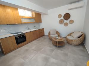 eine Küche mit zwei Stühlen und einem Tisch in der Unterkunft Fos residence in Nea Cryssi Akti