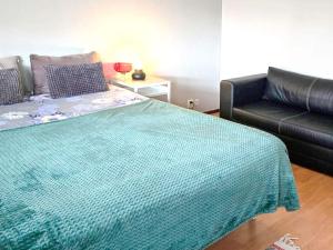 a bedroom with a bed and a leather couch at 4 star holiday home in Ljusne in Ljusne