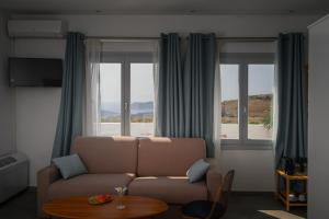 a living room with a couch and two windows at Impressive One in Pyrgos