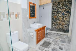 a bathroom with a toilet and a sink and a shower at Unawatuna Nature Villa in Unawatuna