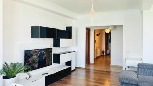a living room with a tv and a couch at Deluxe Criss Solid Residence Mamaia in Mamaia