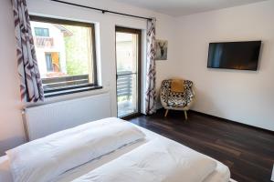 a bedroom with a bed and a tv and a chair at CABANA BERNER stațiunea Mogoșa in Baia-Sprie